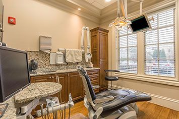 A dental office with a dental chair and a monitor.