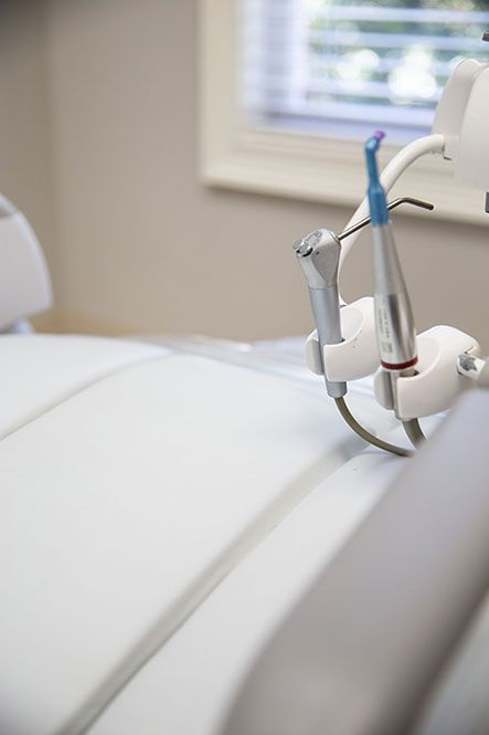 A dental chair with a drill attached to it in a dental office.