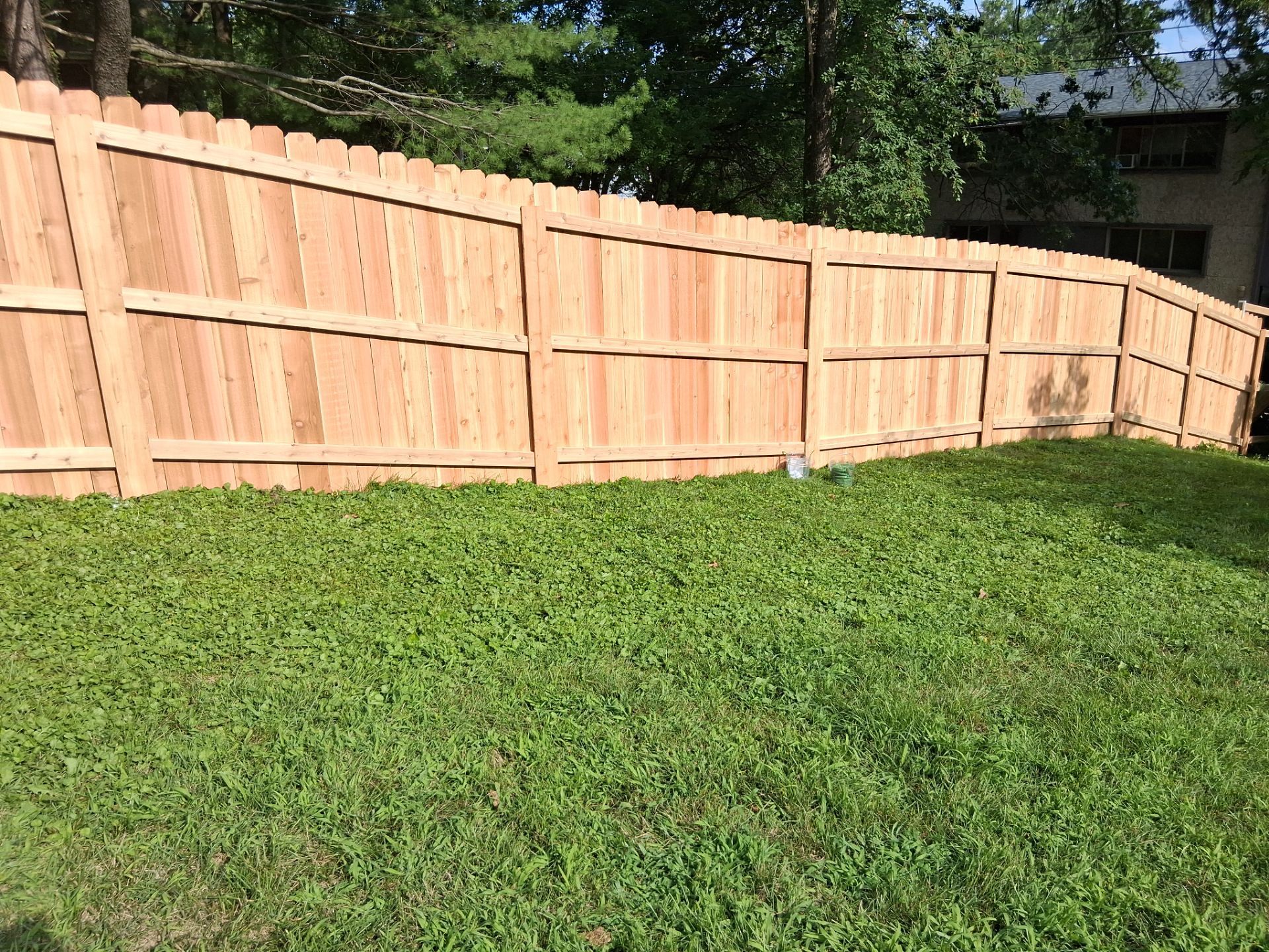 Wooden privacy fence in a grassy yard.