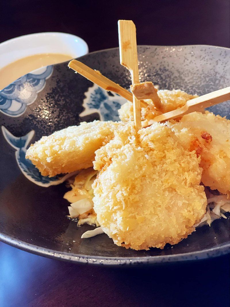 A close up of a plate of food with chopsticks on a table.
