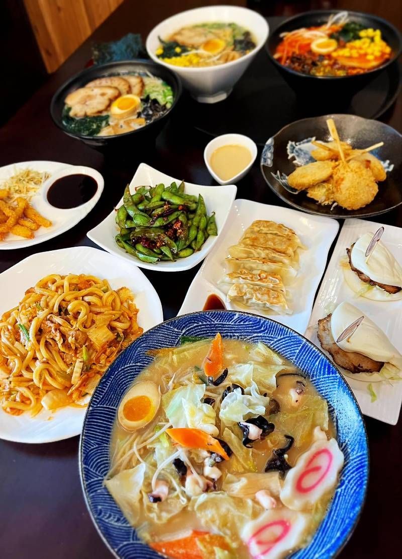 A table topped with plates of food and a bowl of soup.
