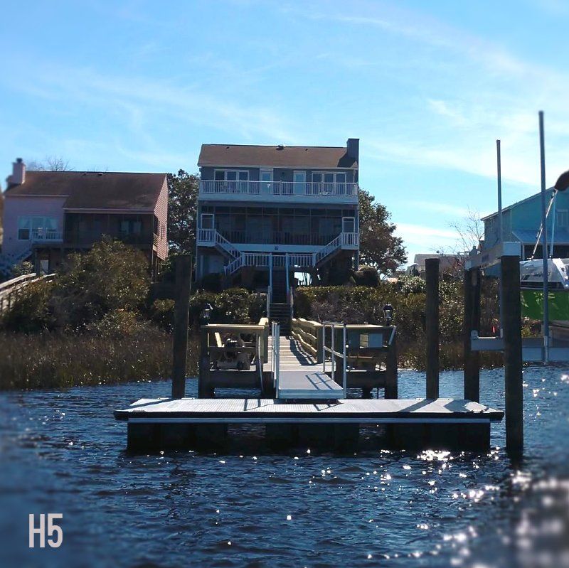 A dock with a house in the background and the letters h5 on the bottom