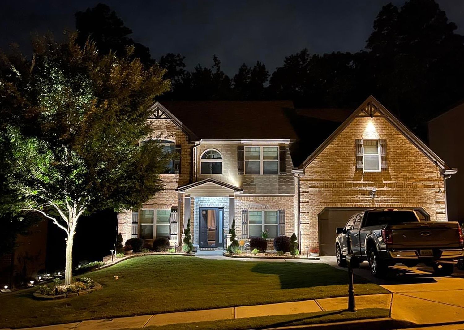 A house with a truck parked in front of it at night