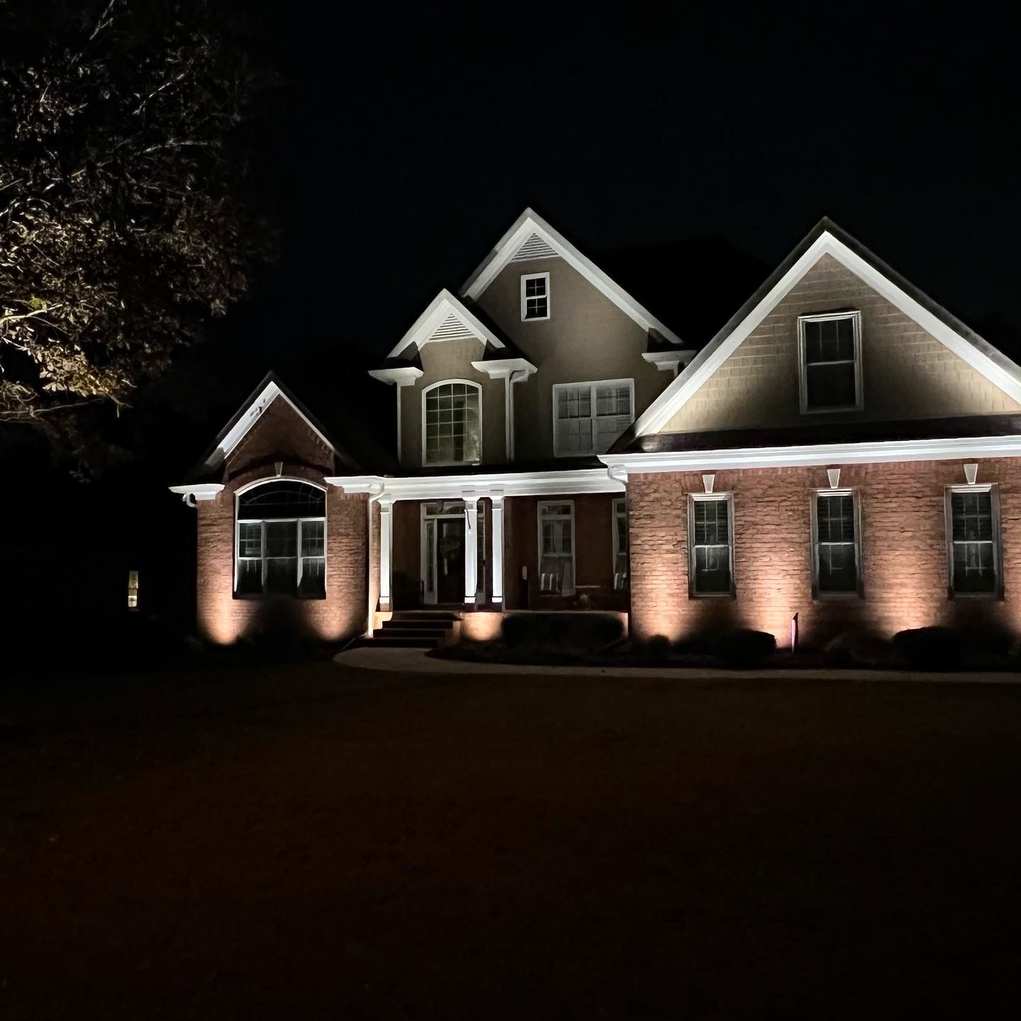 A large brick house is lit up at night