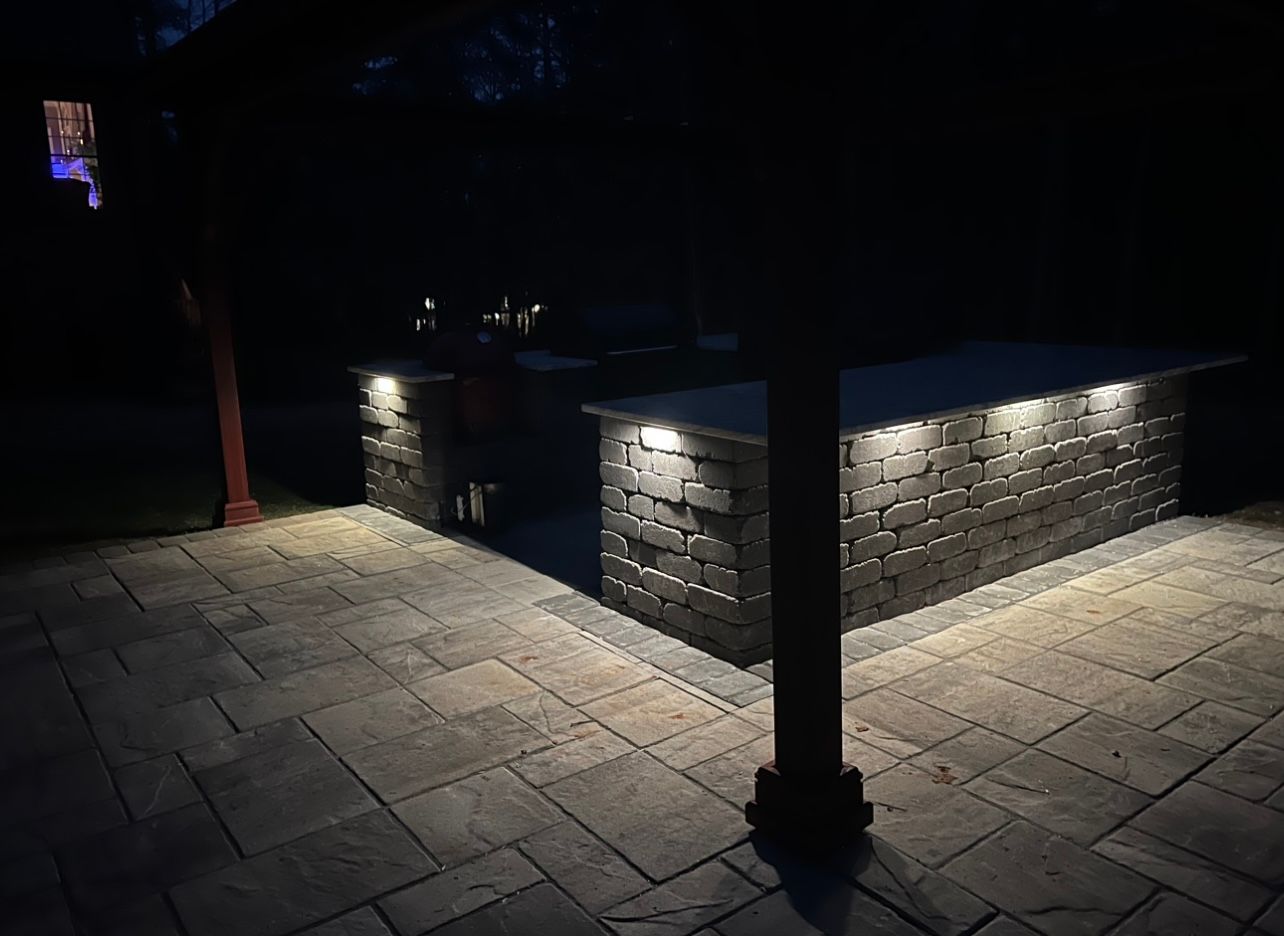 A brick patio with lights on it at night.