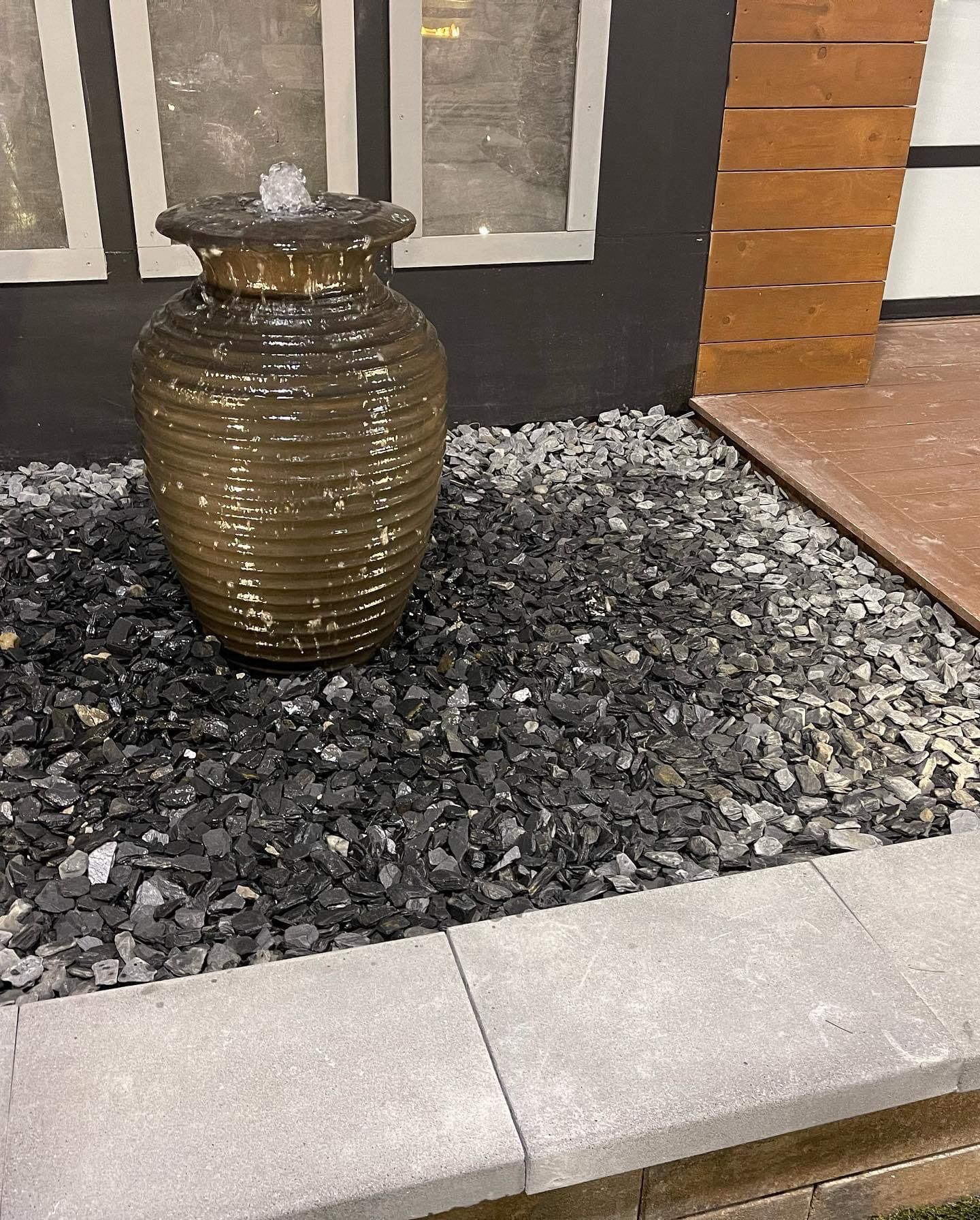 A large vase is sitting on top of a pile of rocks.