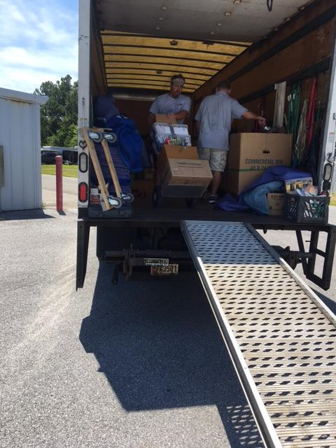 A man is loading boxes into a moving truck