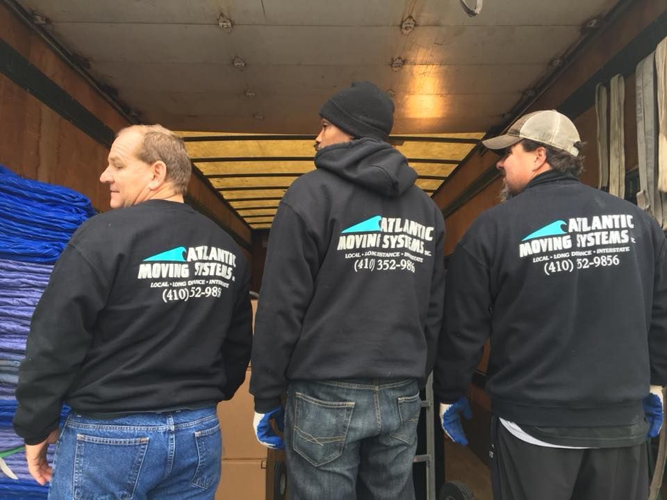 Three men wearing shirts that say atlantic moving systems