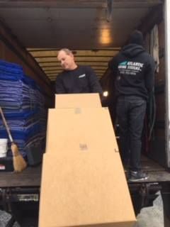Two men are loading boxes into a truck.