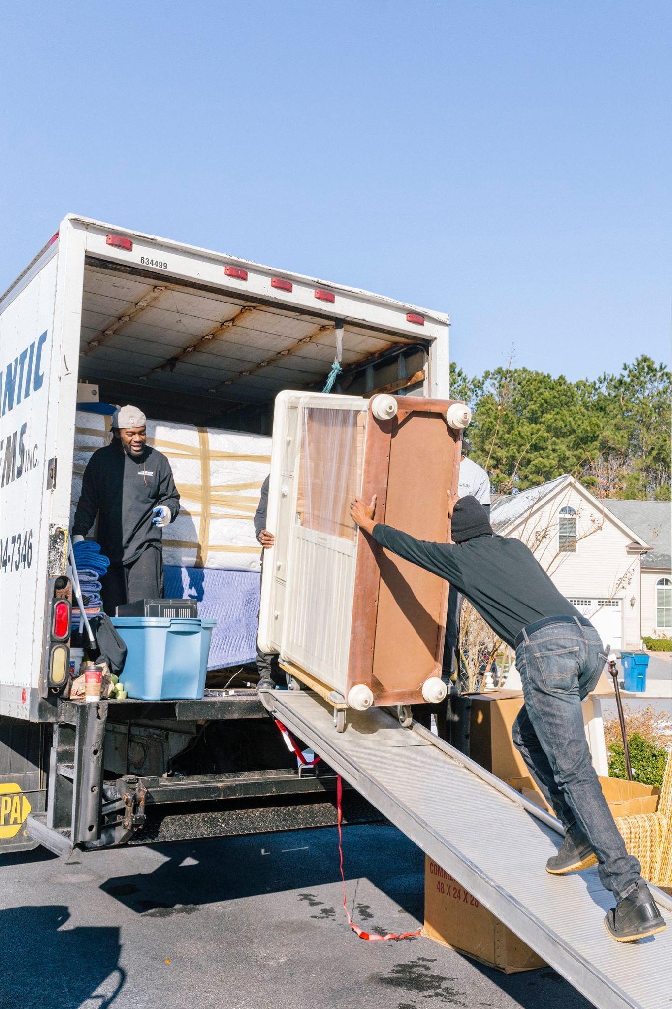 A man is loading a couch into a moving truck.