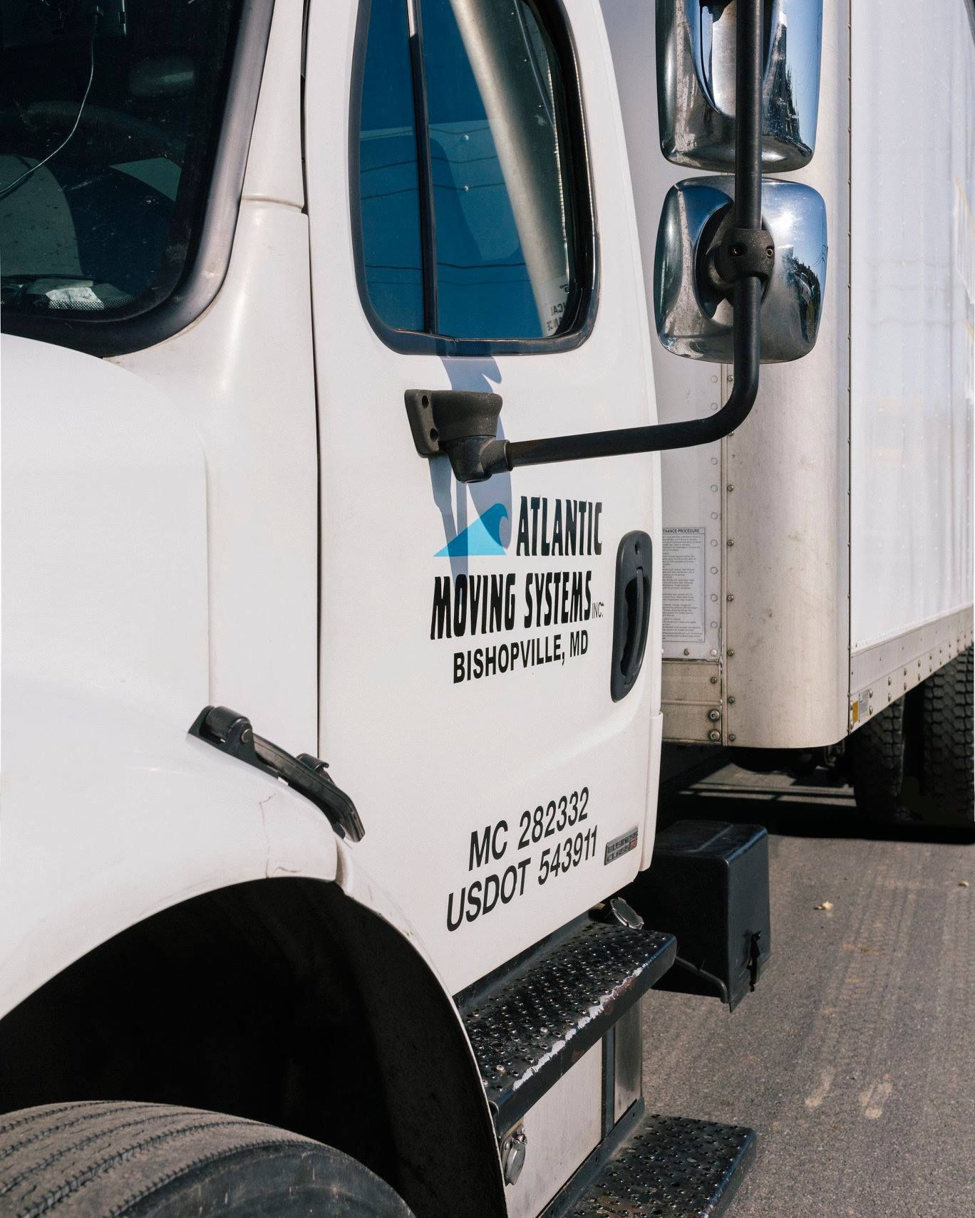A white truck with atlantic moving systems written on the side