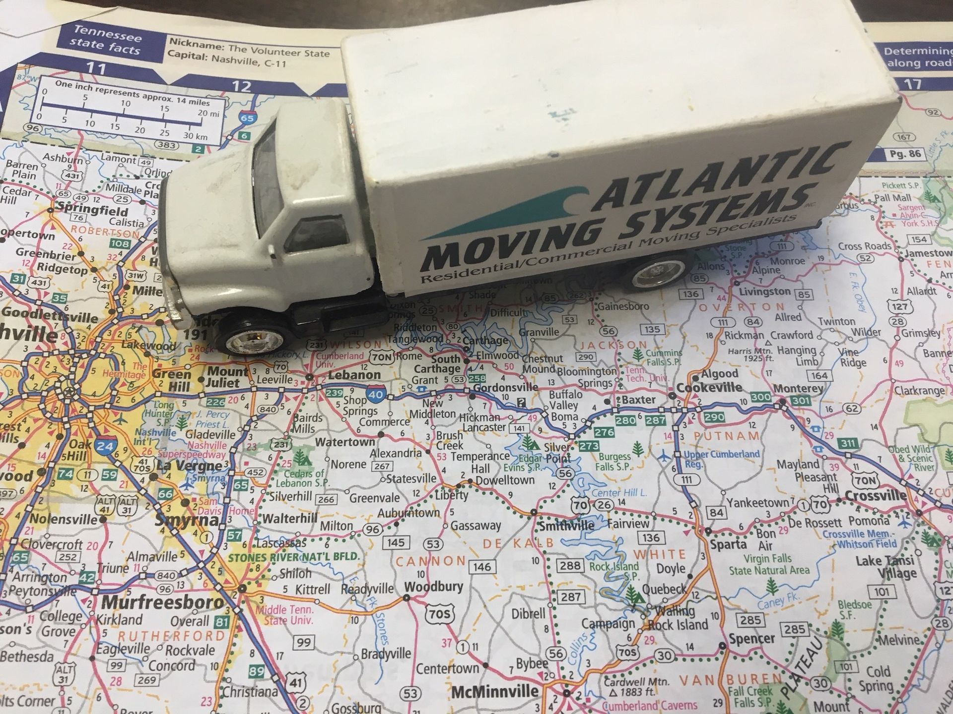 A toy truck from atlantic moving systems sits on top of a map