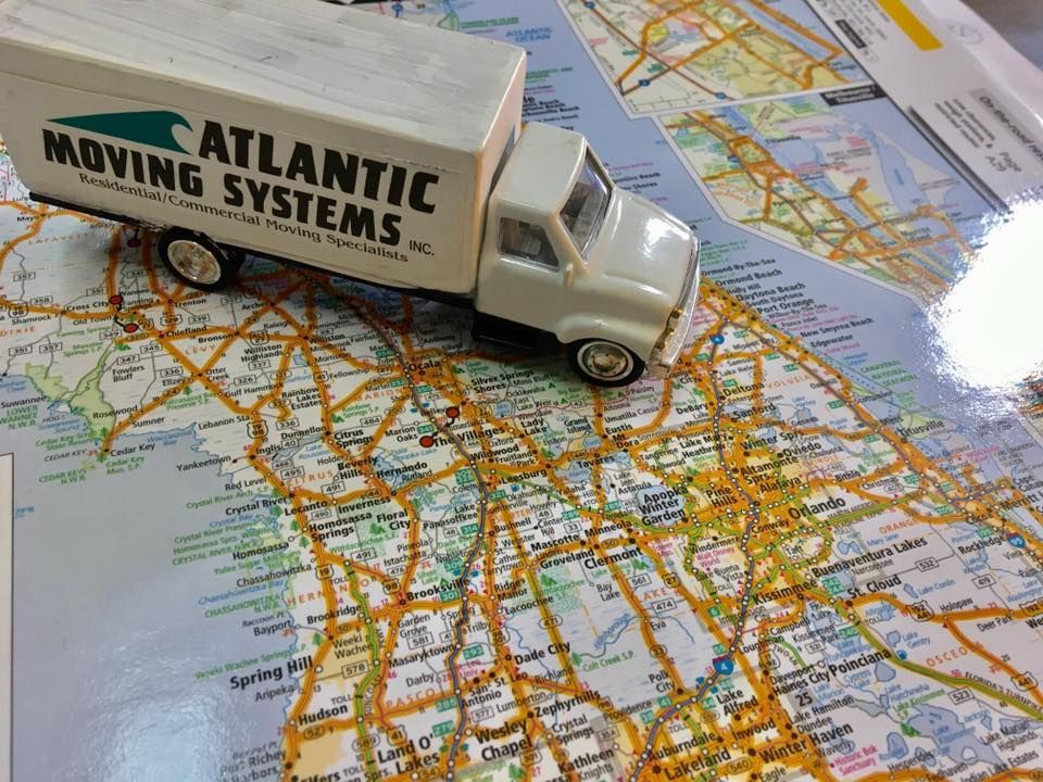 A toy truck from atlantic moving systems sits on top of a map