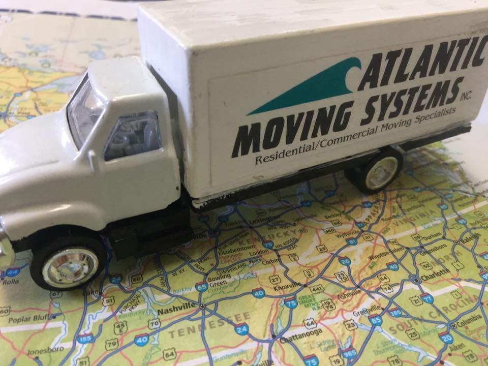 A toy moving truck is sitting on top of a map.