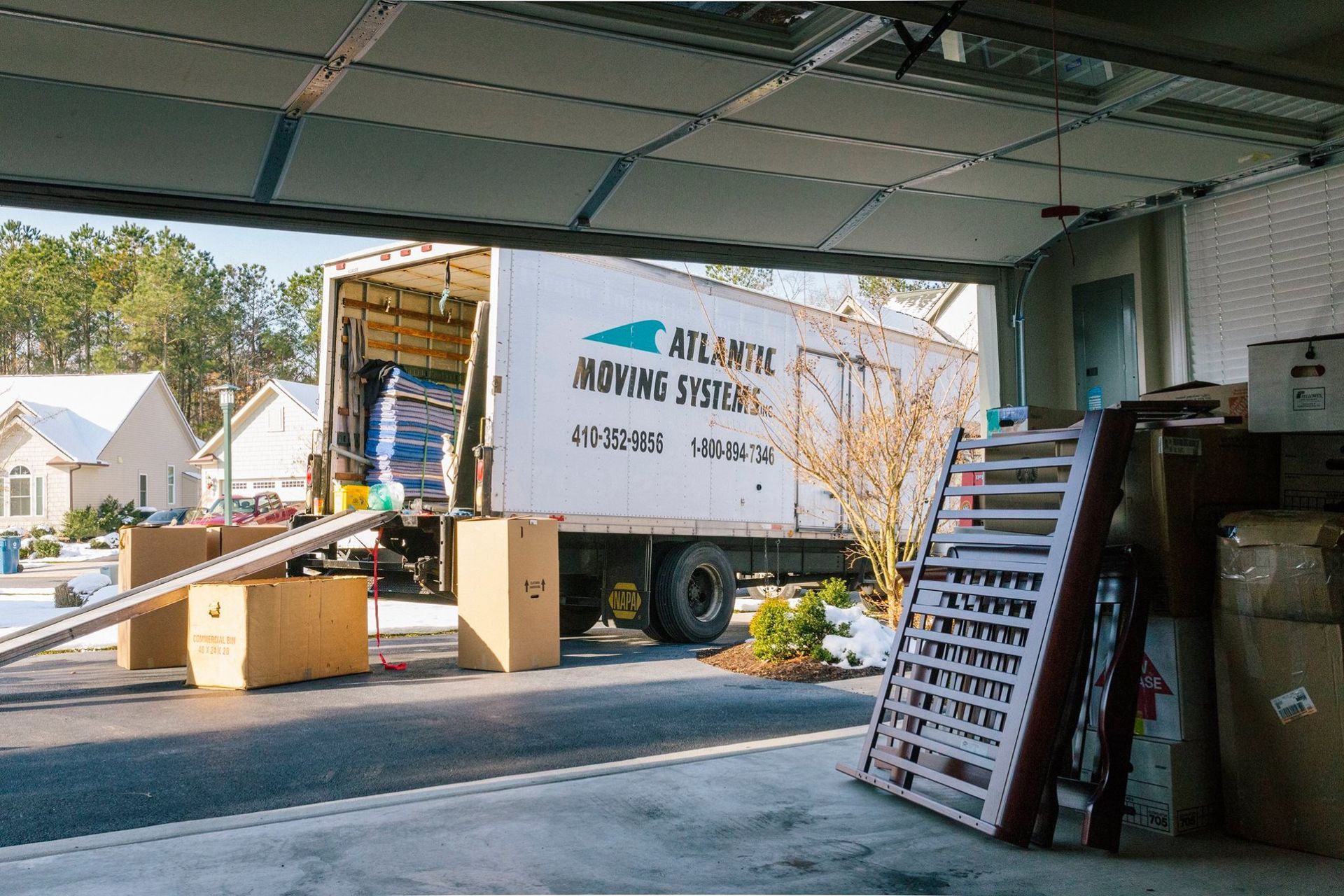 A moving truck is loading boxes into a garage.