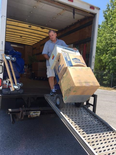 A man is pushing a cart full of boxes on a ramp