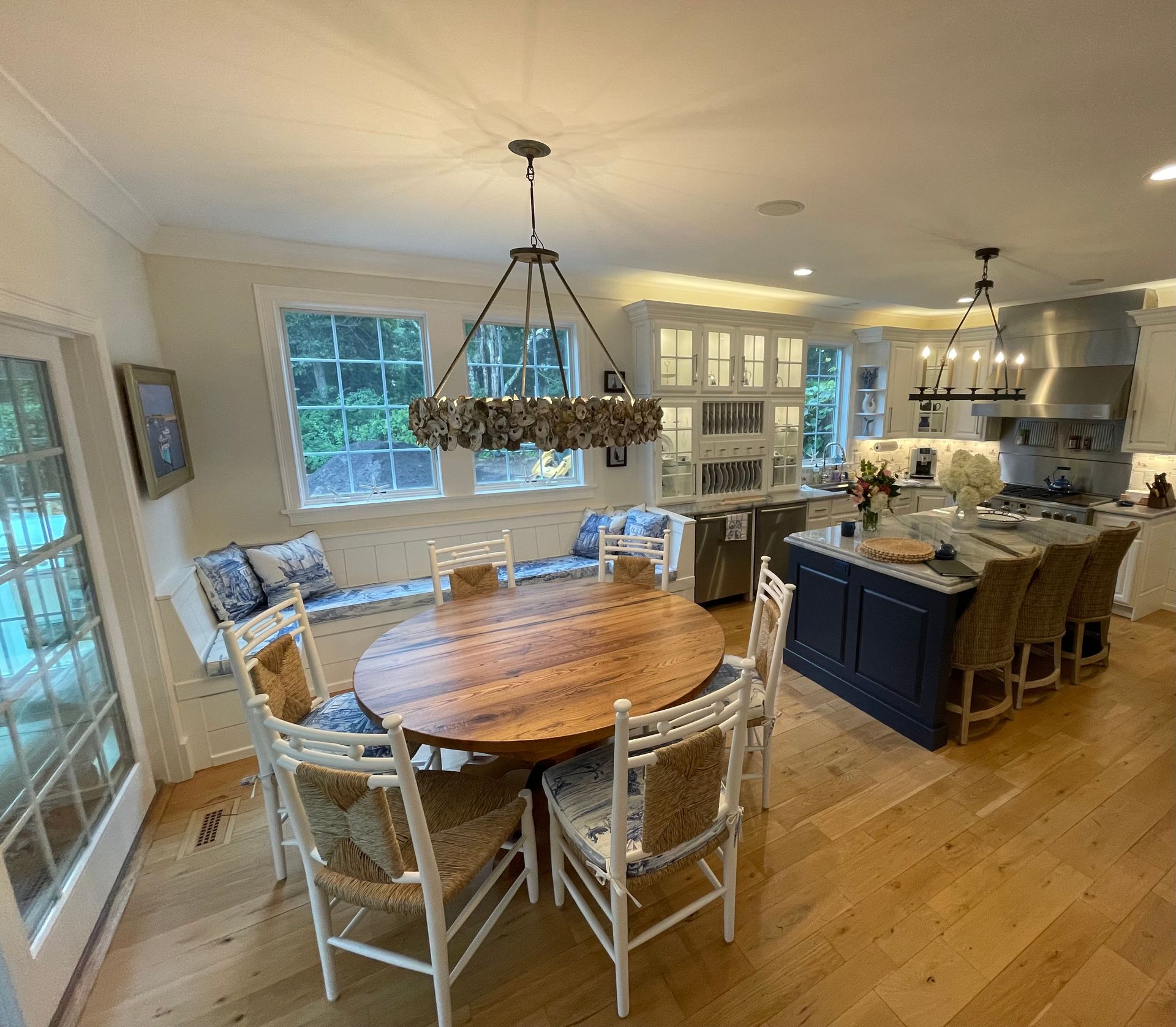 A kitchen with a round table and chairs and a chandelier hanging from the ceiling.