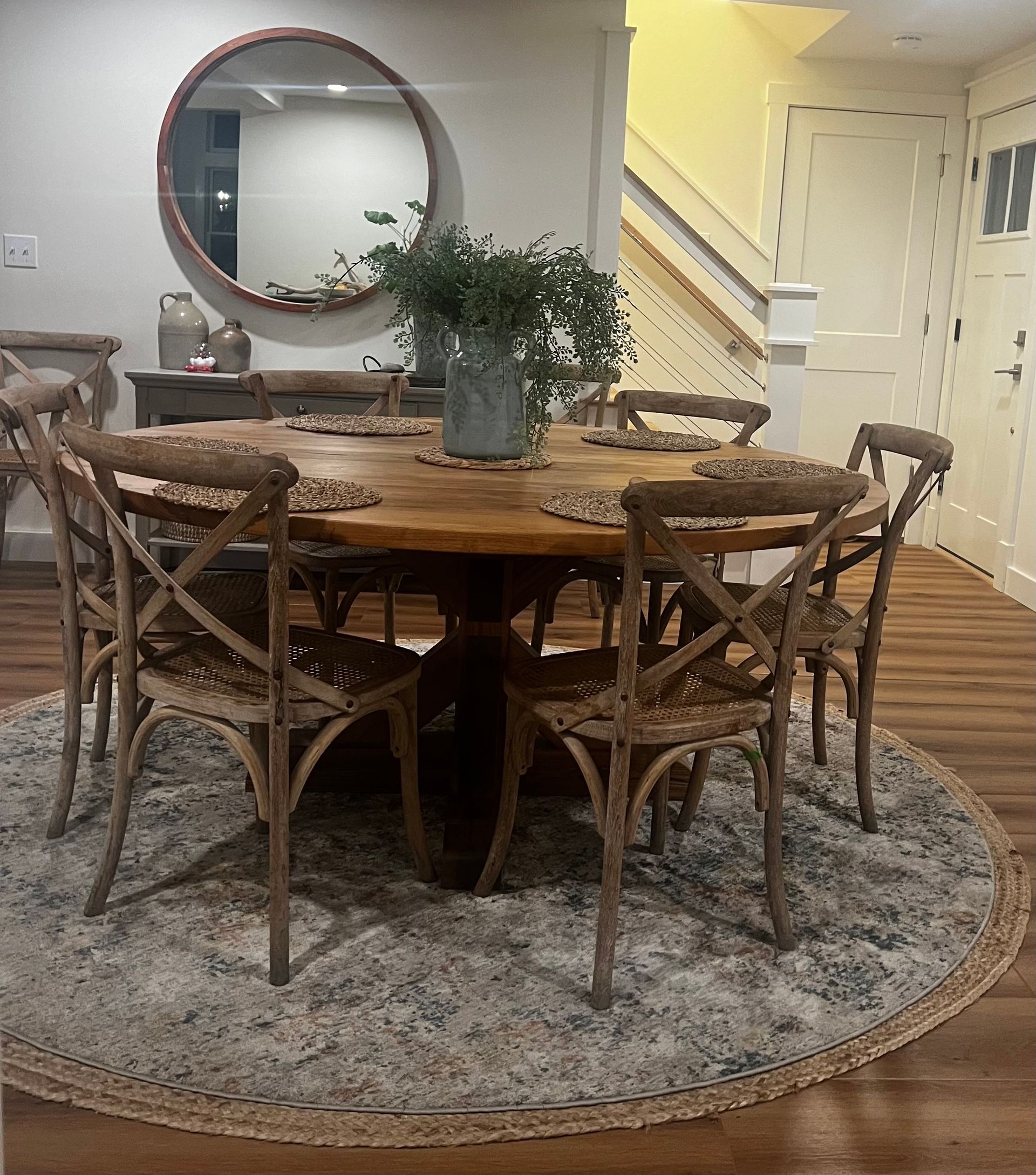 A dining room with a round wooden table and chairs.