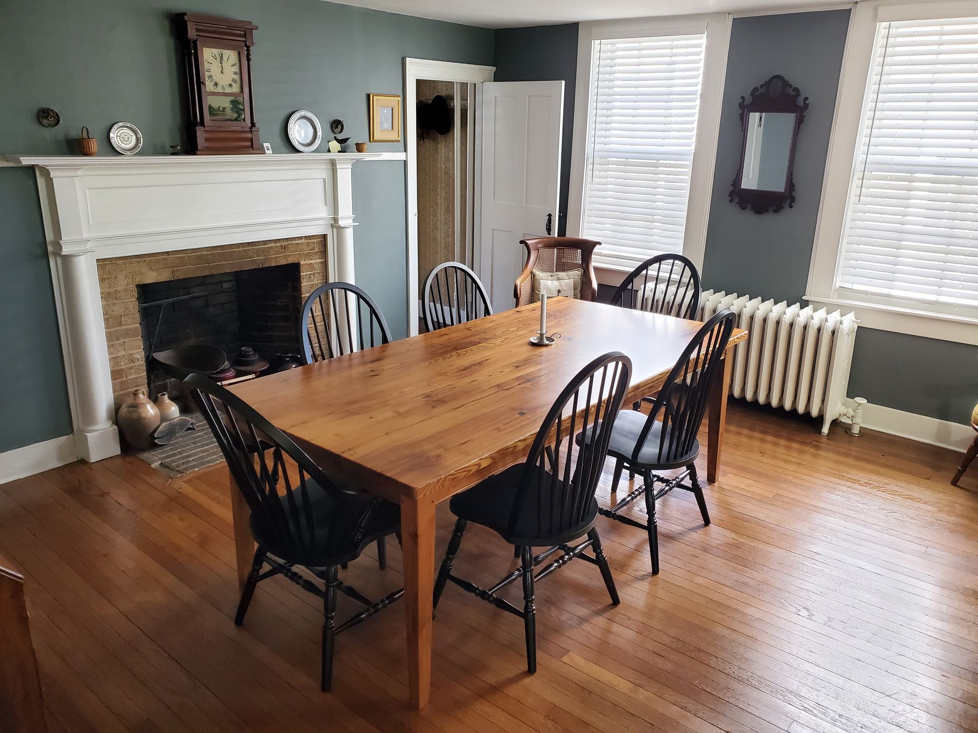 A dining room with a table and chairs and a fireplace.