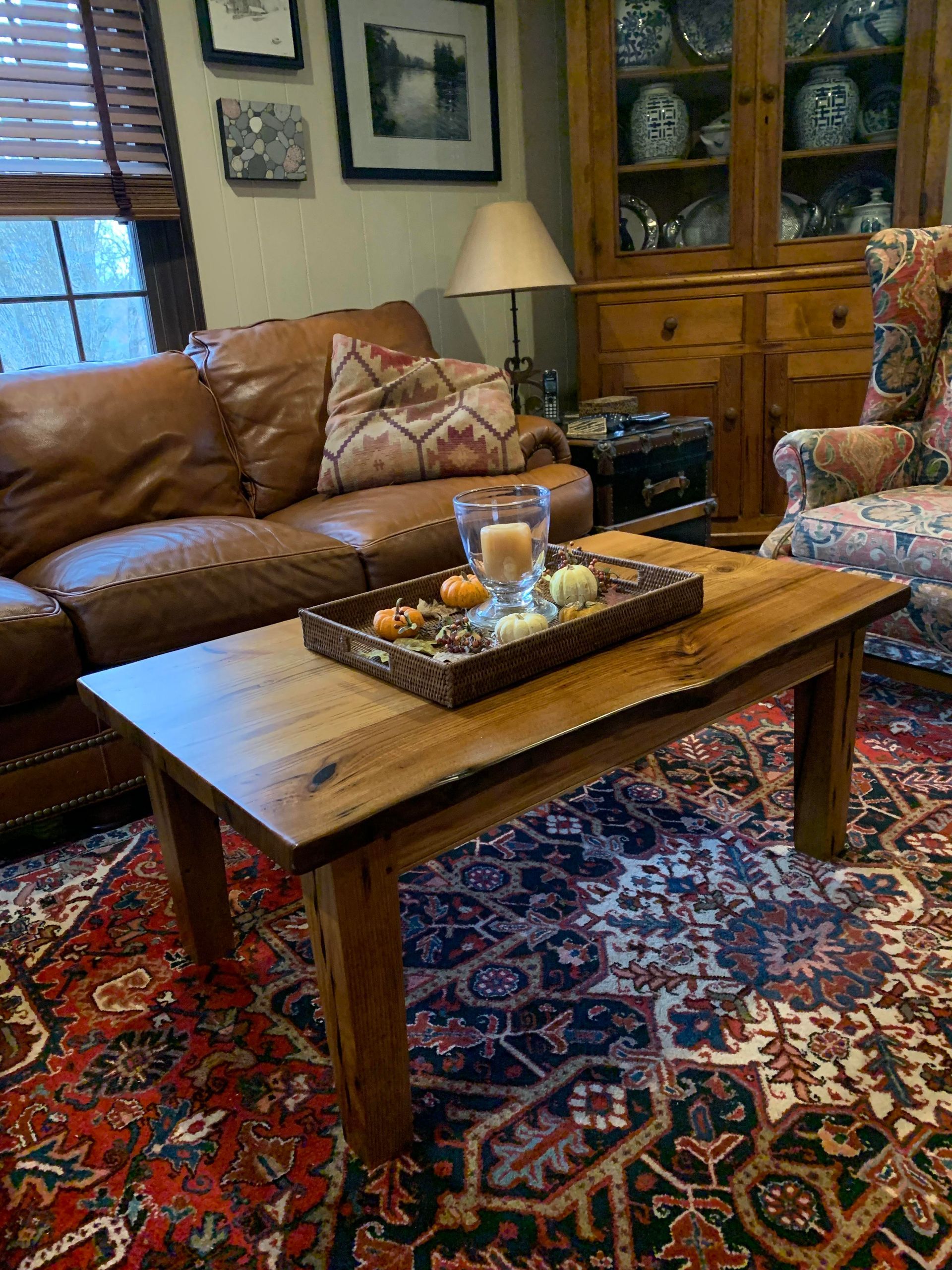 A living room with a couch , chair , coffee table and rug.