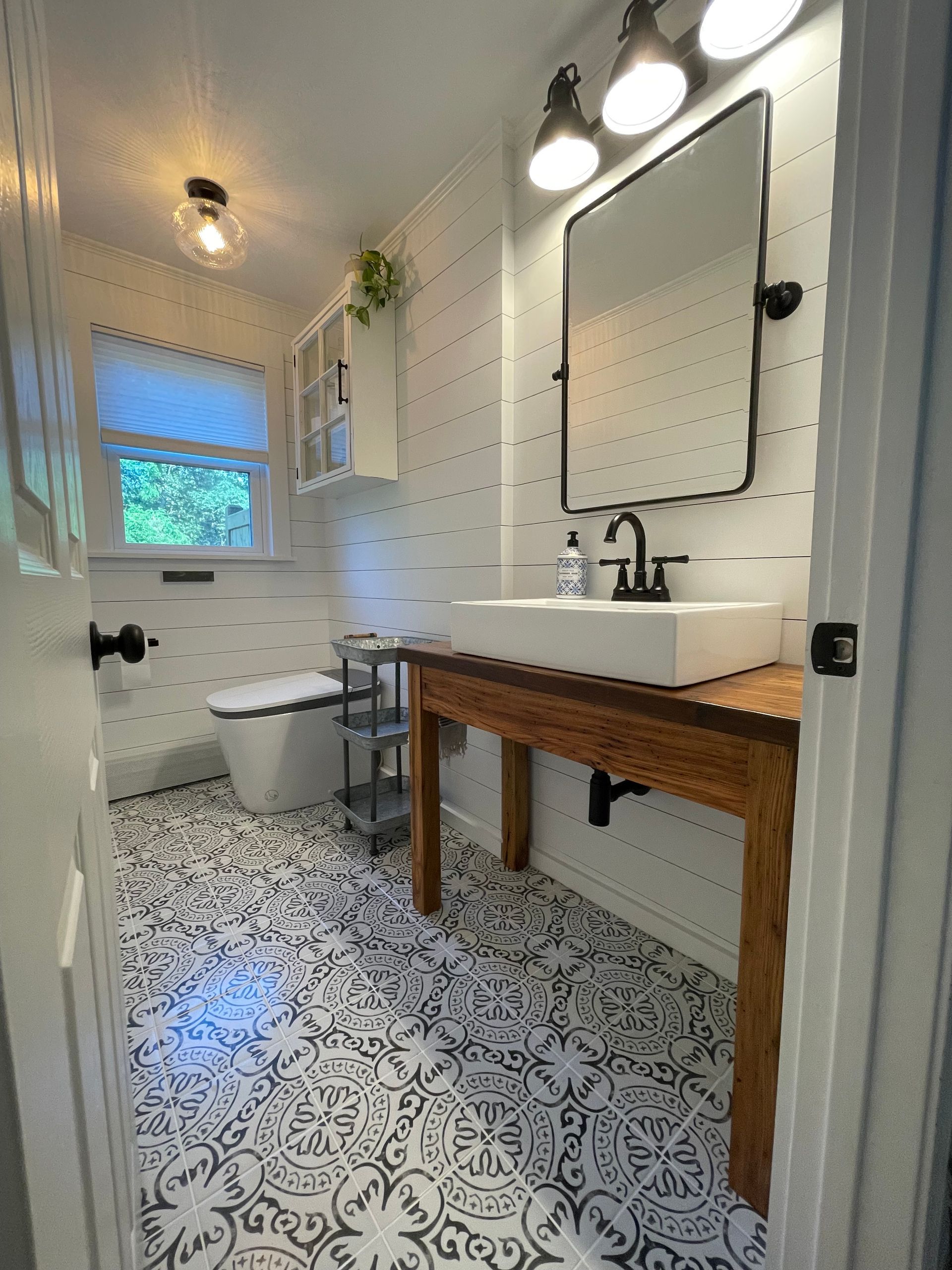 A bathroom with a sink , toilet and mirror.