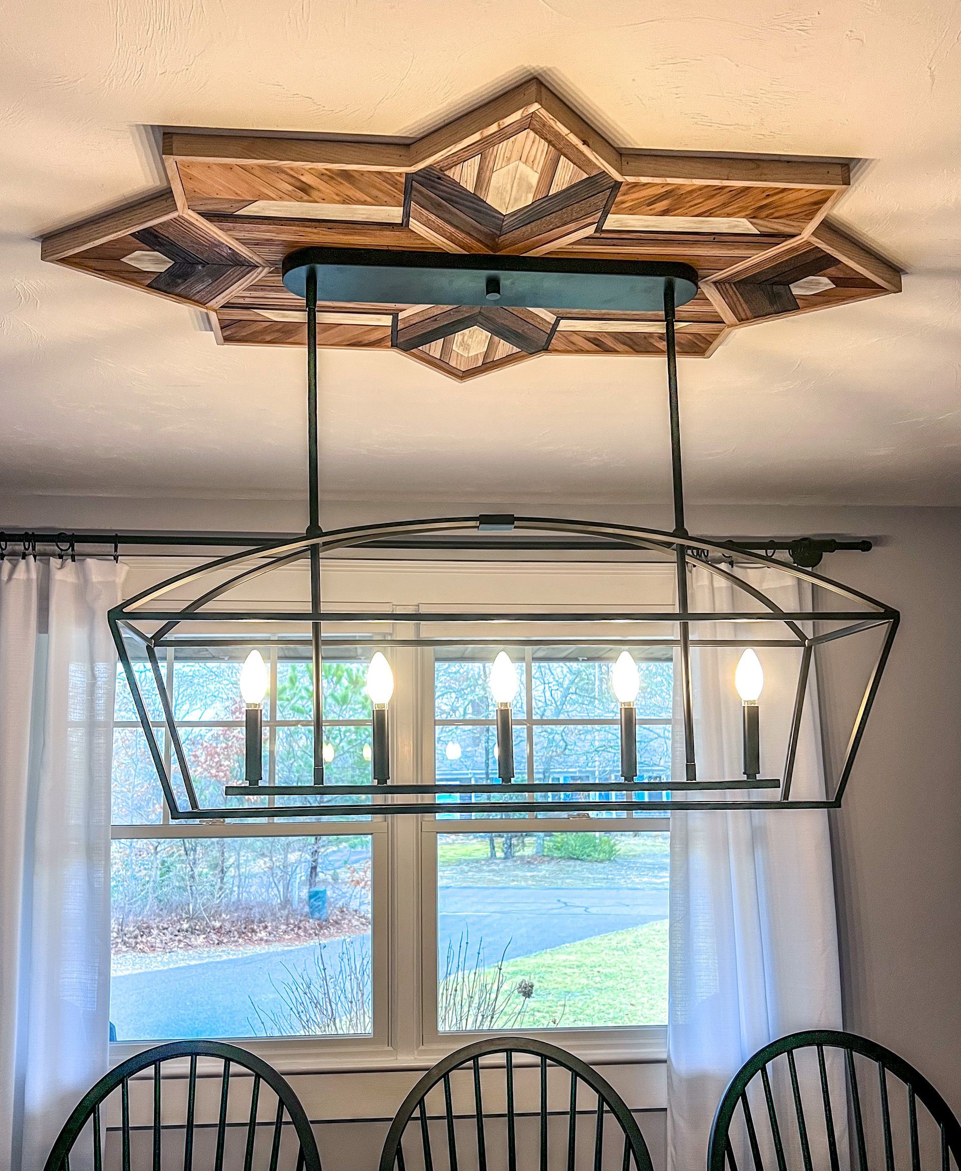 A dining room with a chandelier hanging from the ceiling.