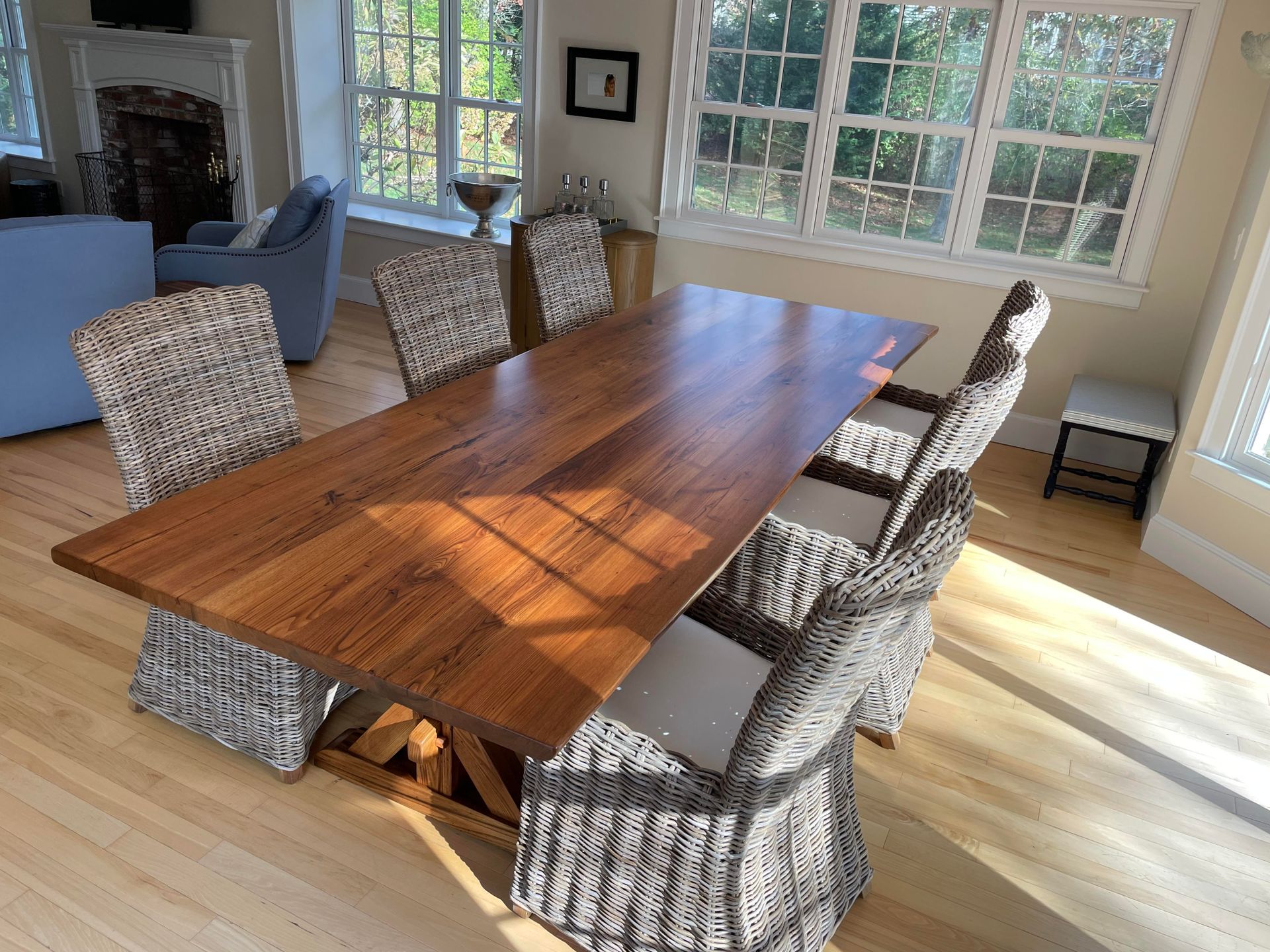 A wooden dining table with wicker chairs in a living room.