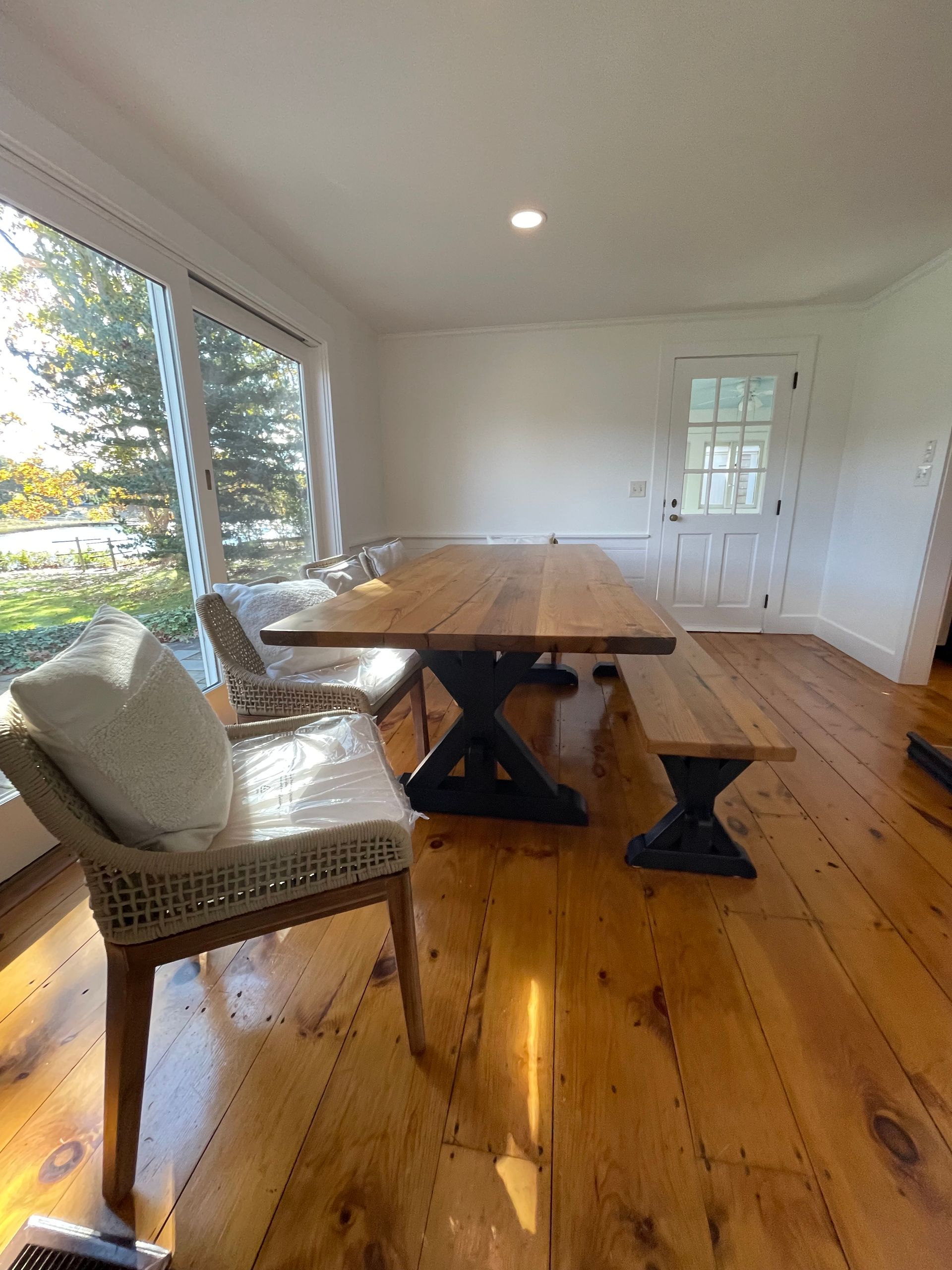 A dining room with a table and chairs and a bench.