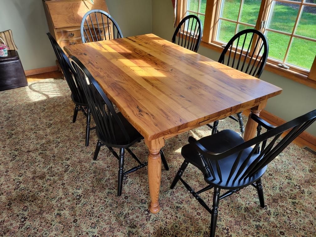A wooden table and chairs in a room with a window.