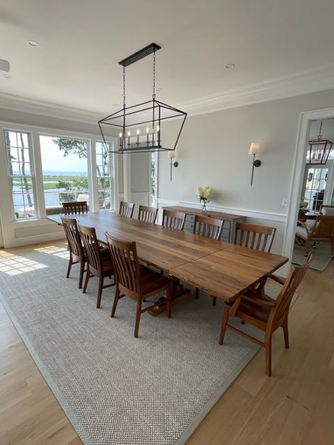 A dining room with a long wooden table and chairs