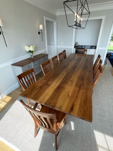A dining room with a long wooden table and chairs