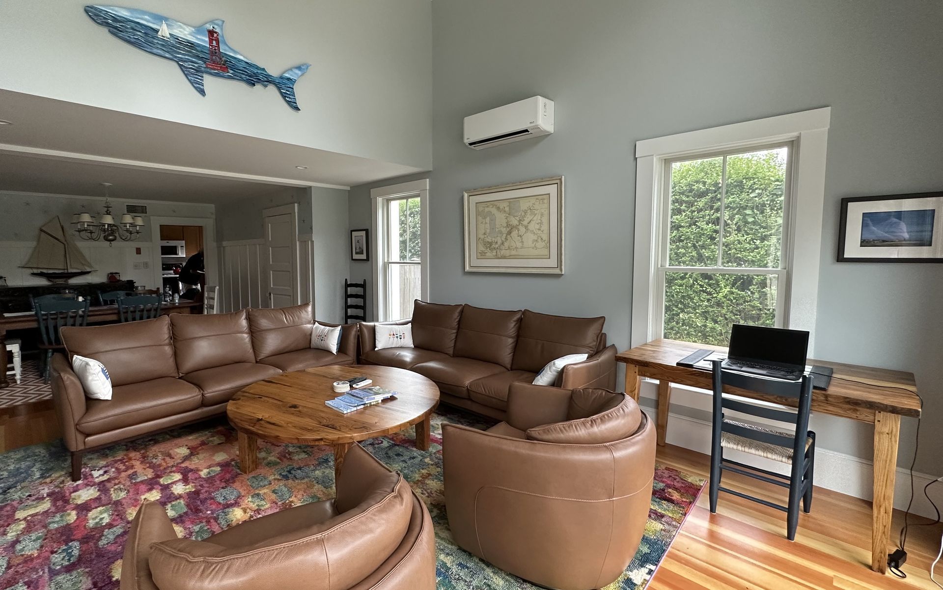 A living room filled with furniture and a desk with a laptop on it.