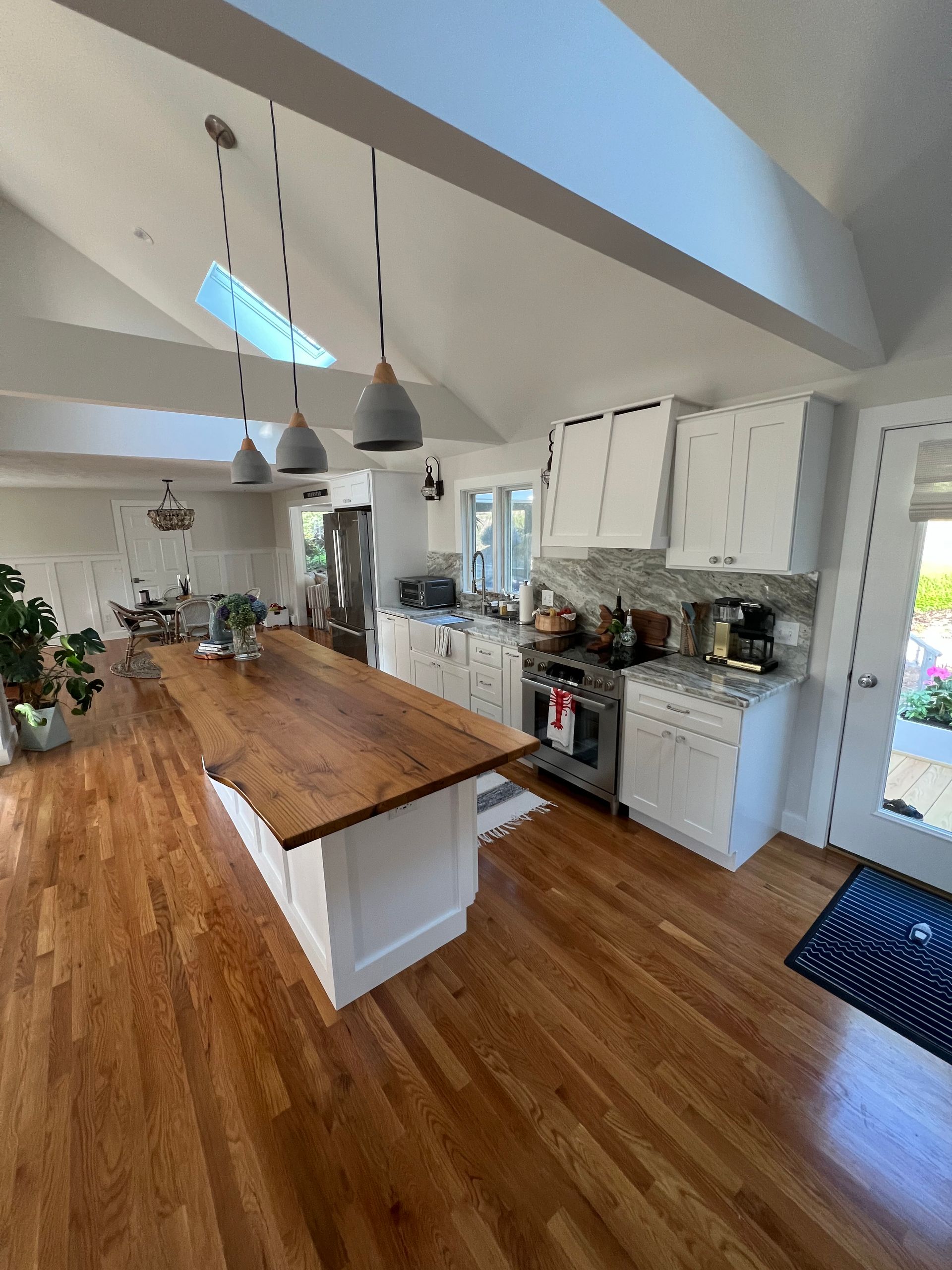 A kitchen with a large wooden table and hardwood floors.