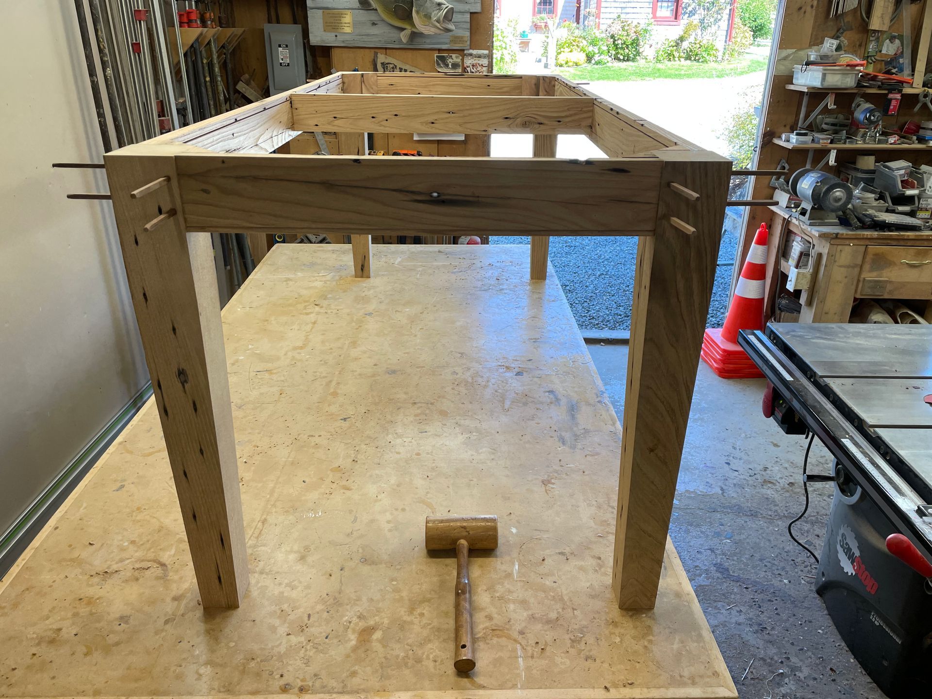 A wooden table is sitting on top of a wooden table with a hammer on it.