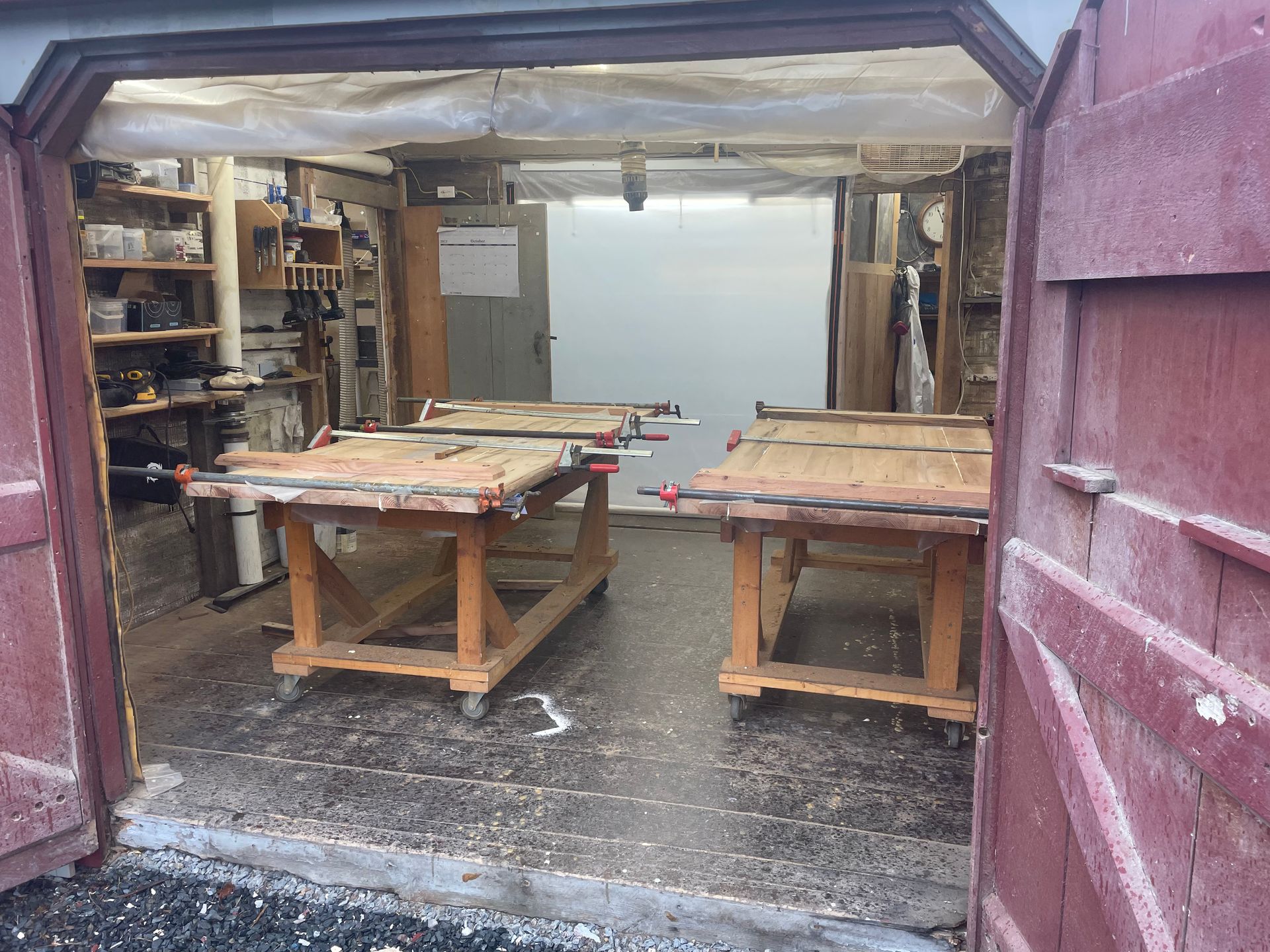 A garage with a lot of wooden tables in it