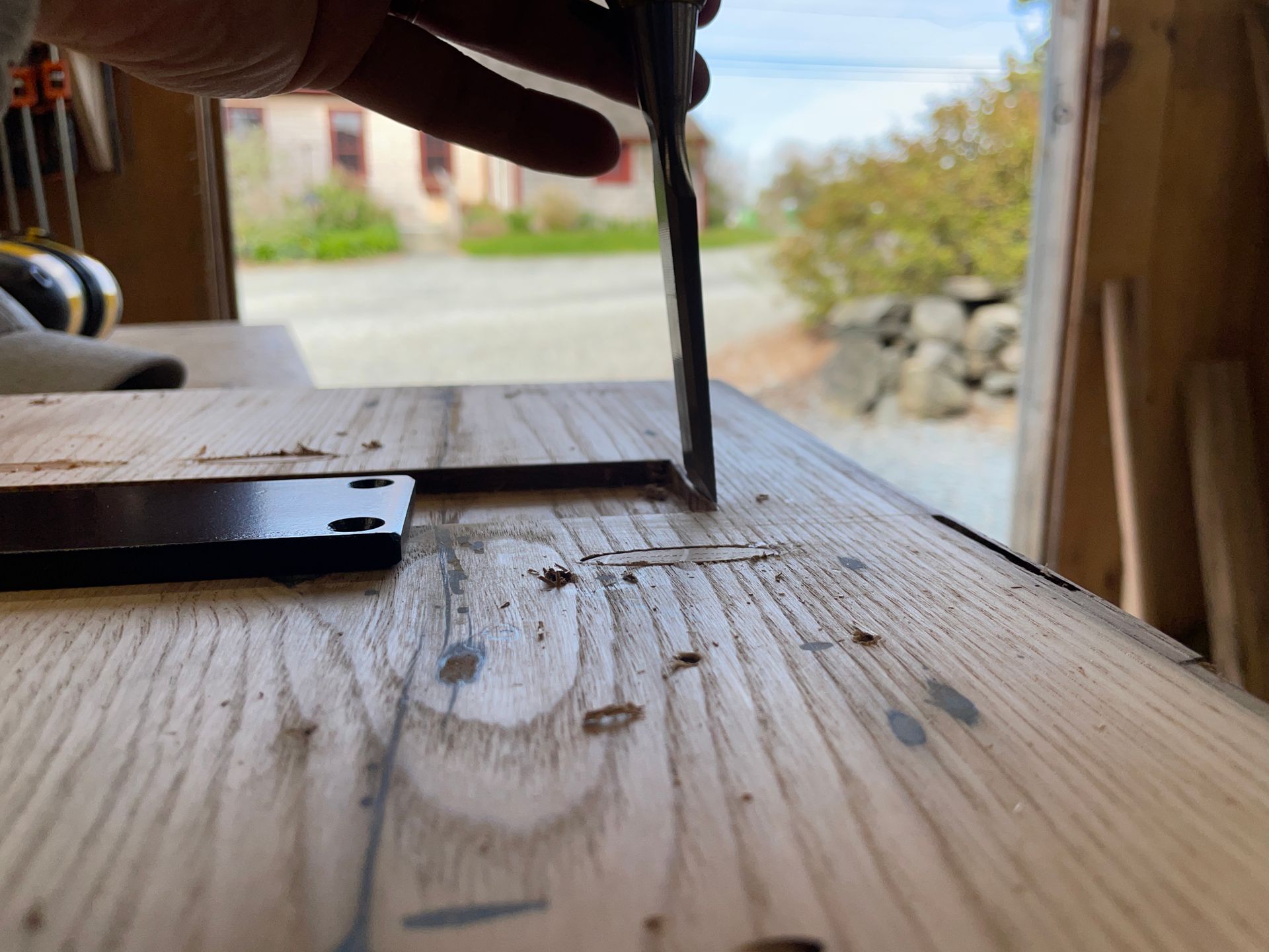 A person is cutting a piece of wood with a pair of scissors