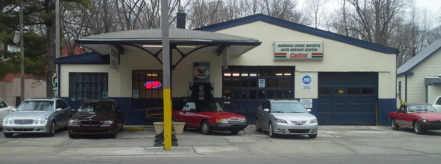 A row of cars are parked in front of a garage