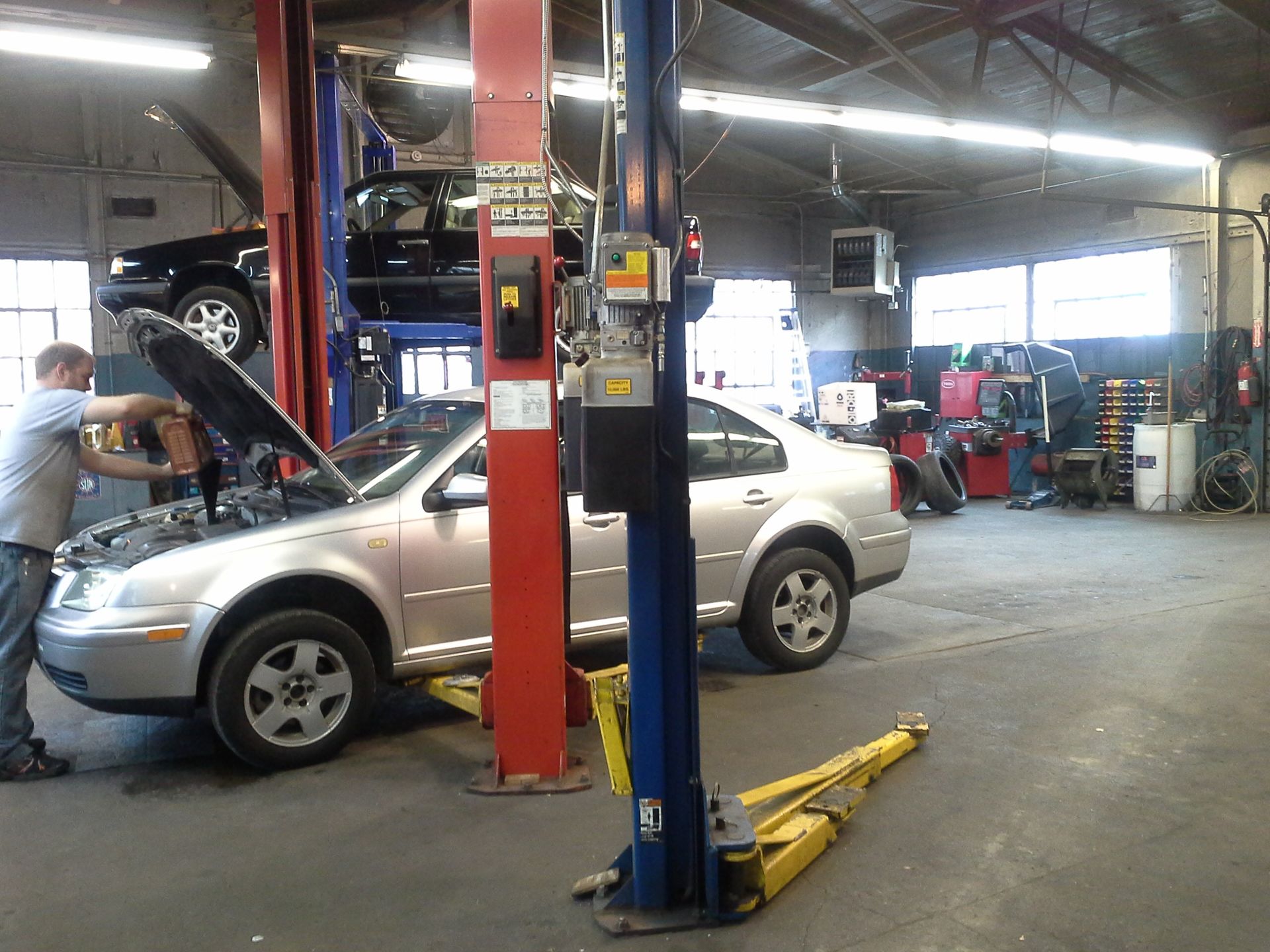 A car on a lift in a garage with the hood open