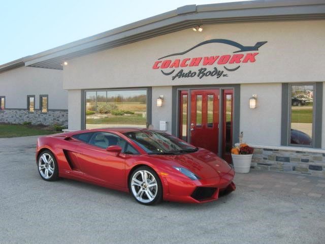 Red Lamborghini Gallardo parked in front of Coachwork Auto Body.