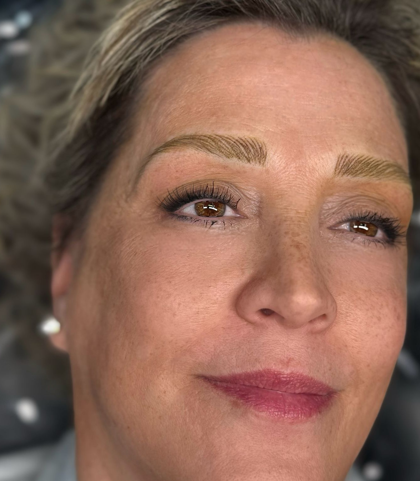 Woman with freshly microbladed eyebrows, brown eyes, and neutral expression.