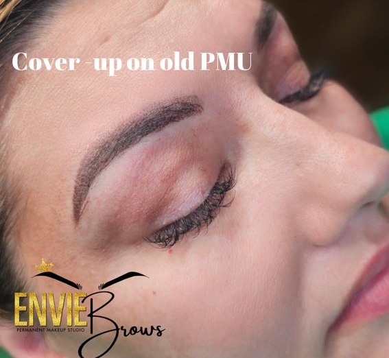 Cover-up permanent makeup on eyebrows. Brown eyebrows over closed eyes. Envie Brows logo.