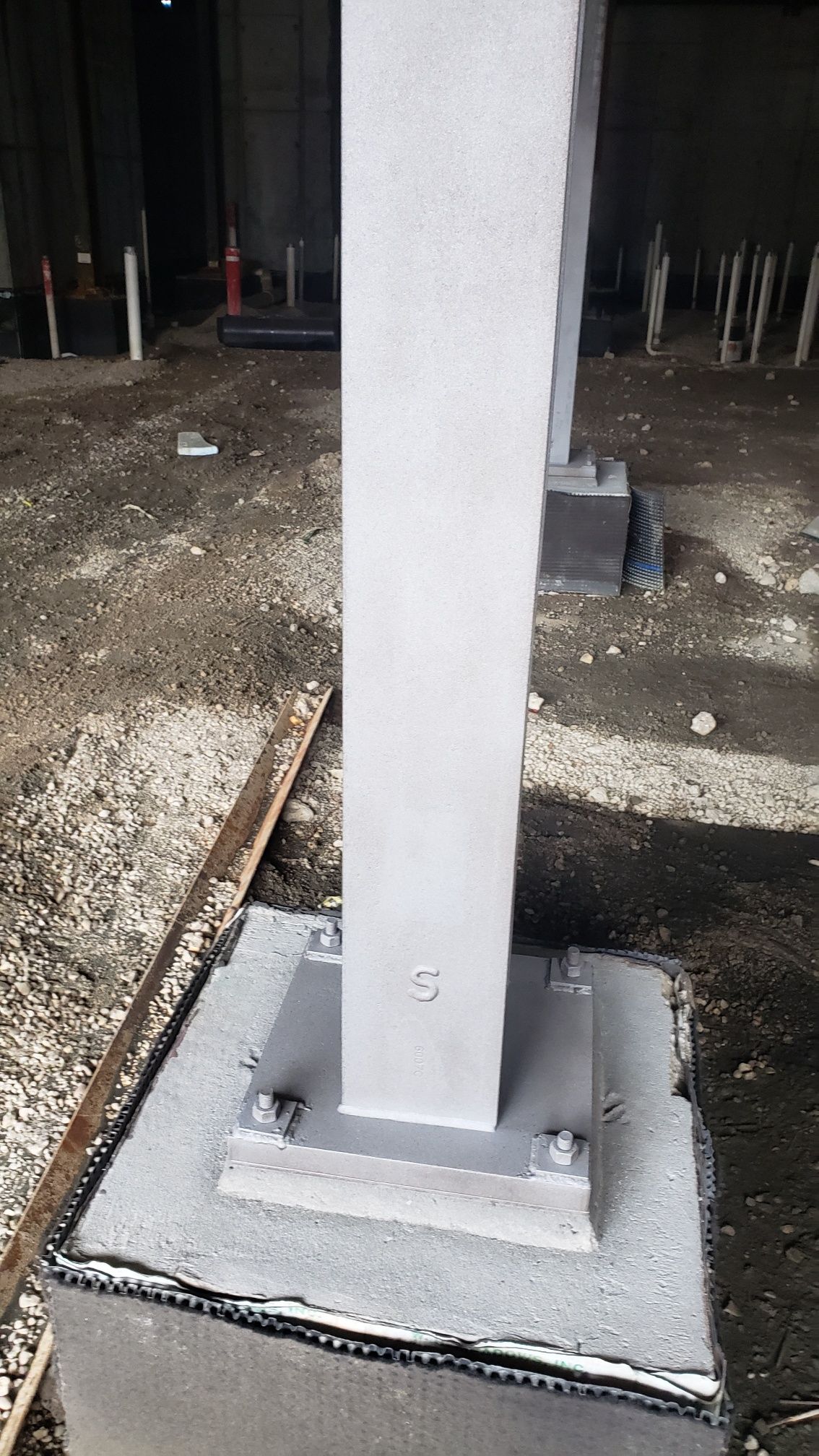 A white pole is sitting on top of a concrete base.