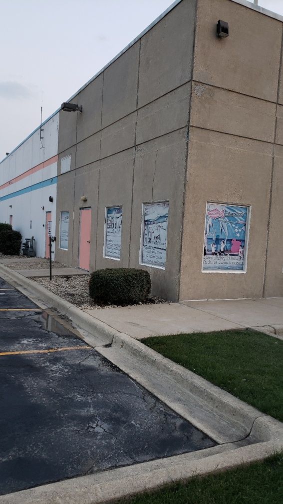 A large concrete building with a parking lot in front of it.