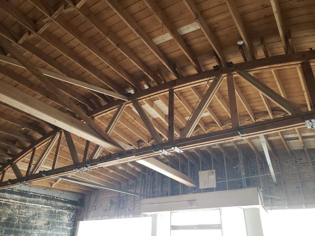 The ceiling of a building with a lot of wooden beams.