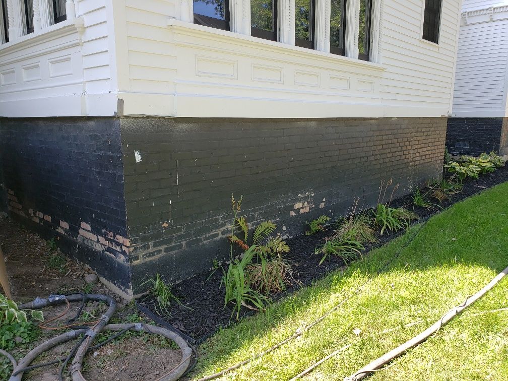 A black and white house with a hose in front of it.