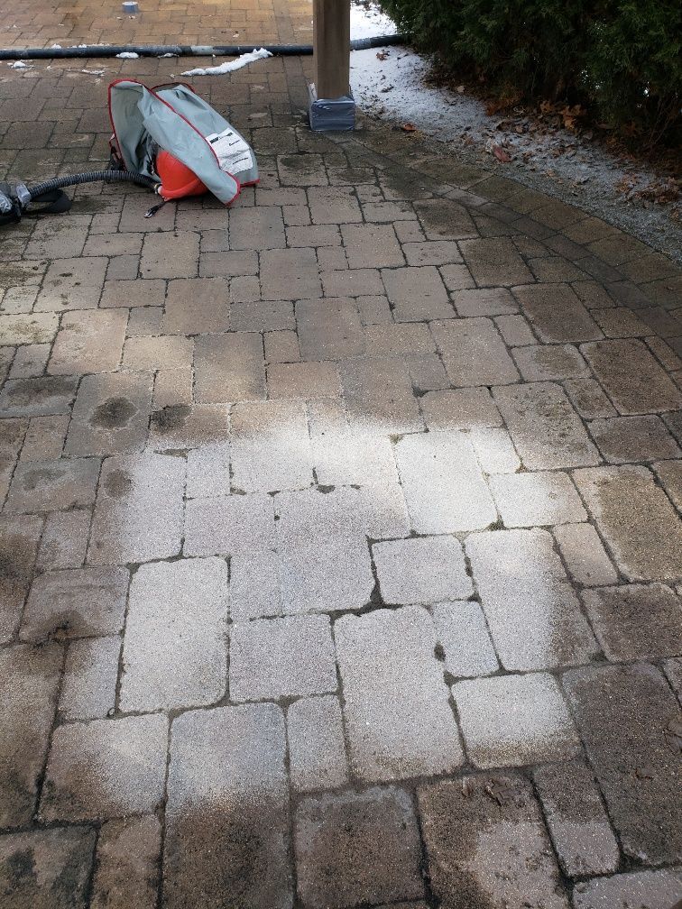 A surfboard is laying on a brick walkway