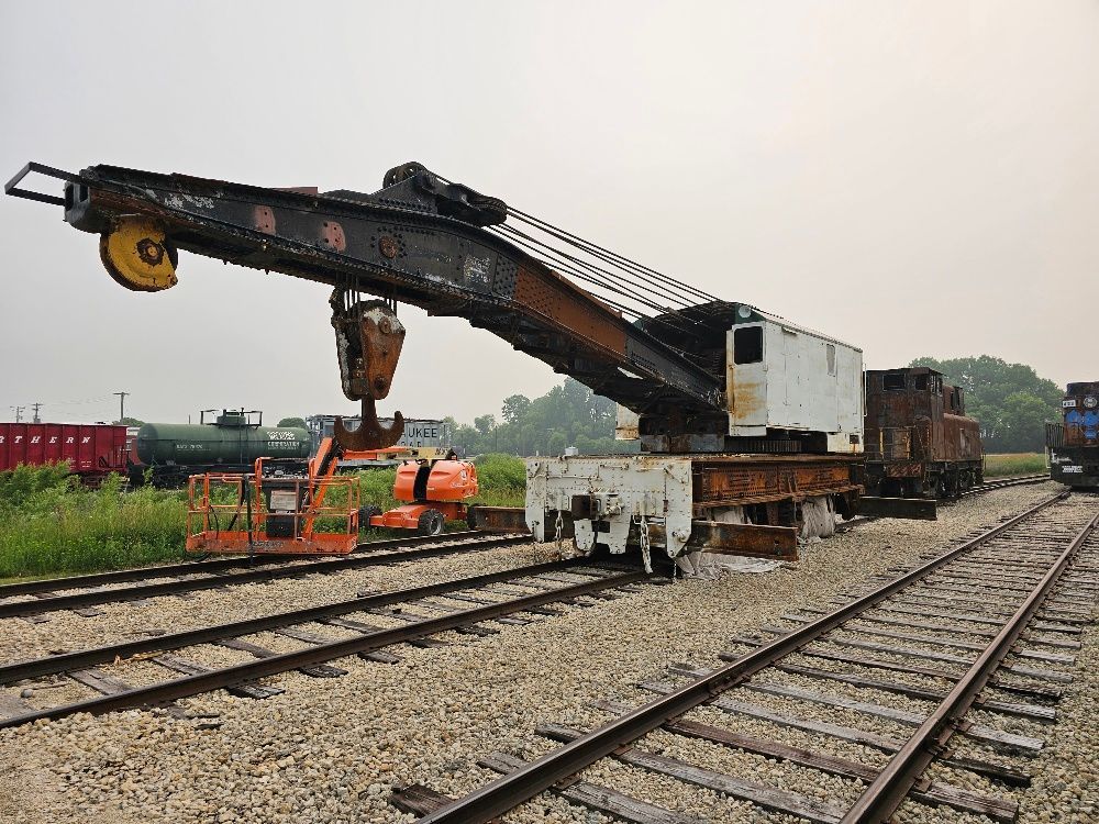A large crane is sitting on top of a train track.
