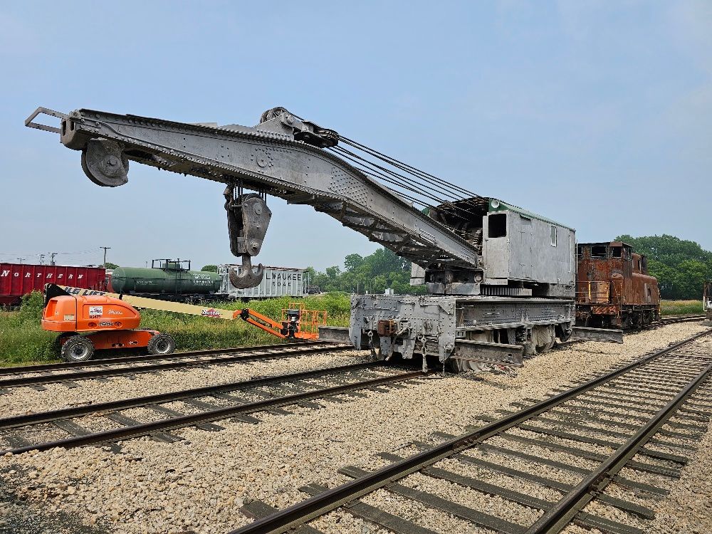 A large crane is sitting on top of a train track.
