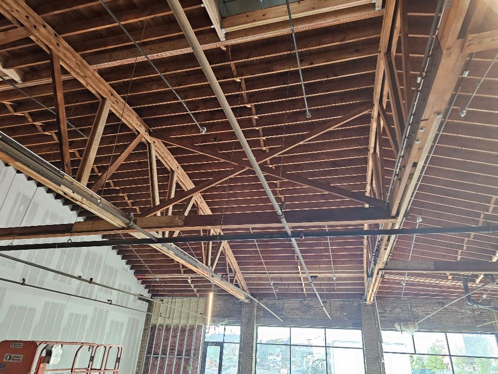 The ceiling of a building with a lot of wooden beams.