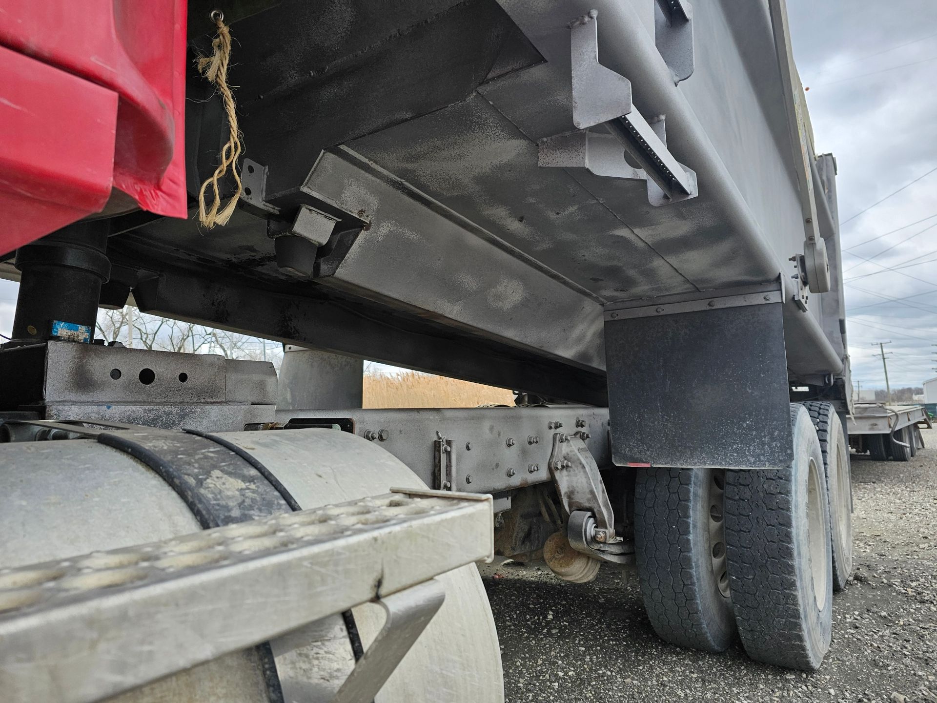 A dump truck is parked in a gravel lot.
